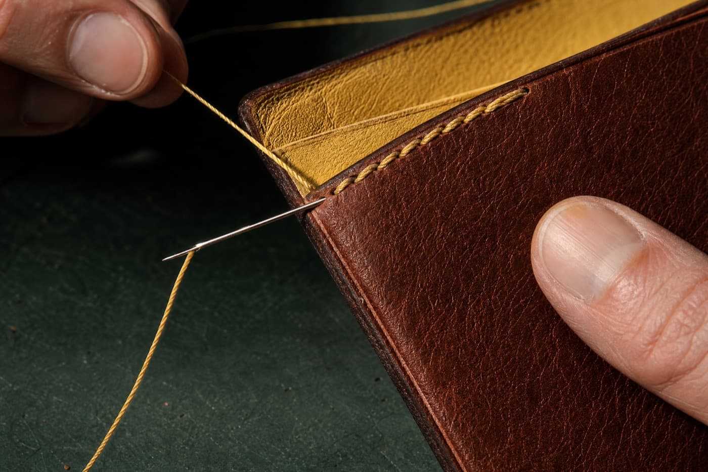 Macro of beeswaxed linen saddle stitching through chestnut leather